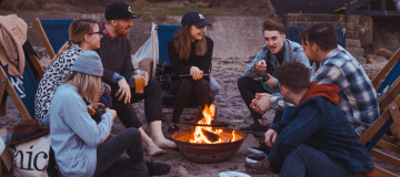 image group of people, seating near the fire in camp and telling histories 